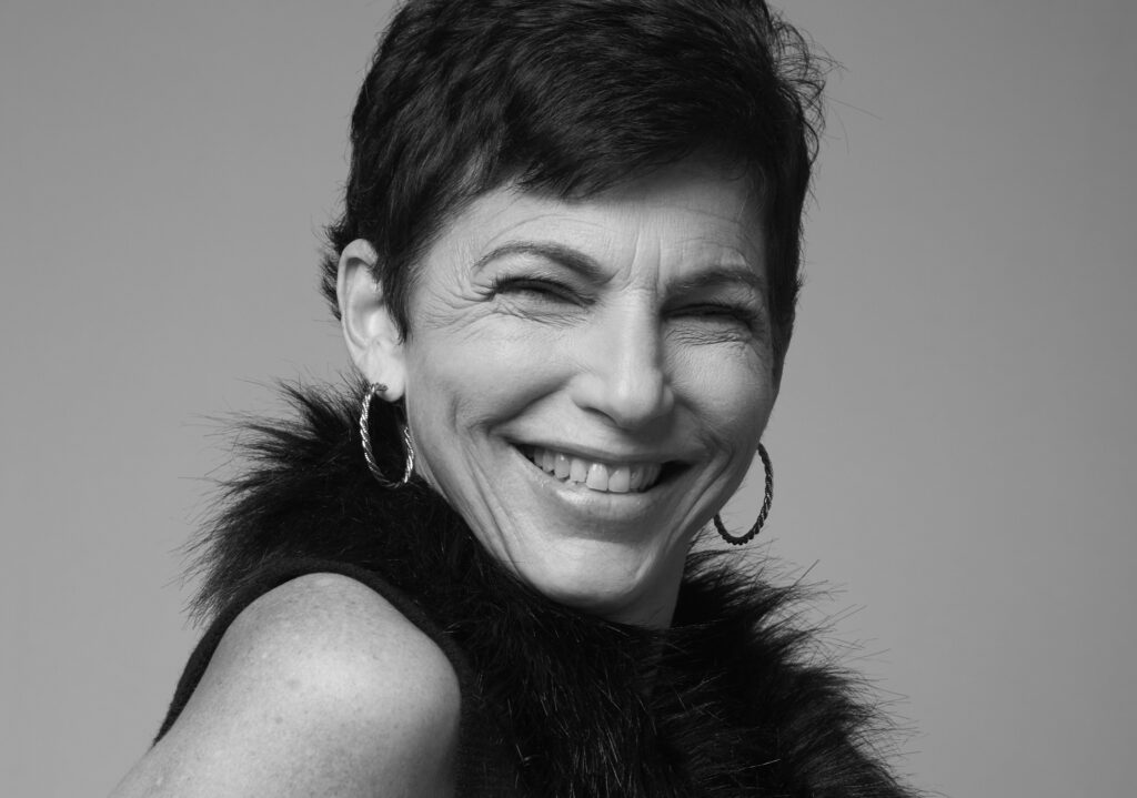 Amy Jordon's headshot. A woman with short dark hair wearing a fuzzy-collared shirt